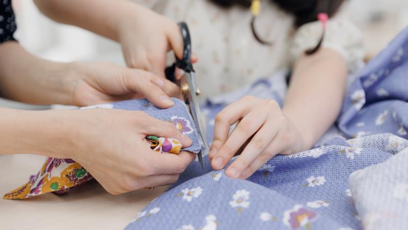 kid using scissors to cut fabric